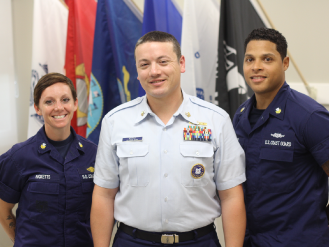 three coast guard members in uniform at the CM veterans lounge