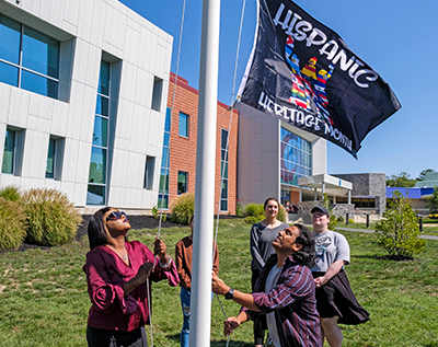 Students raising flag for Hispanic Heritage Month