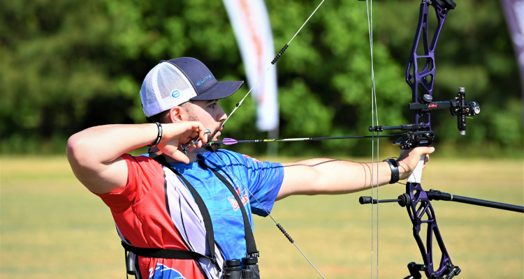 a photo of Matthew Byrnes holding a bow and arrow