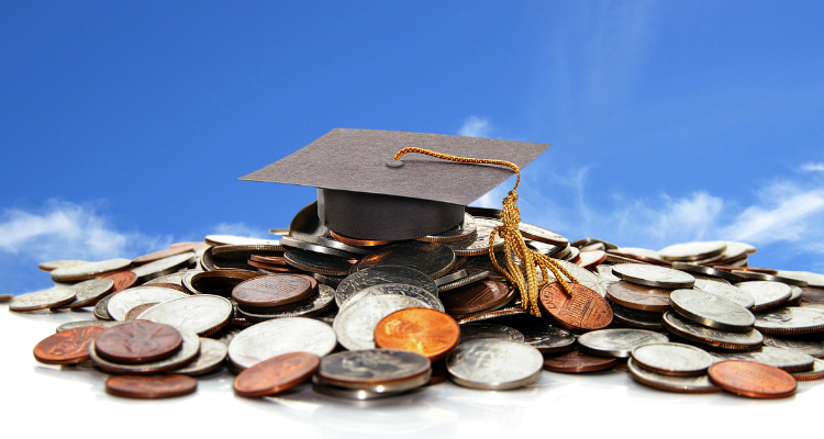 graduation cap on top of coins