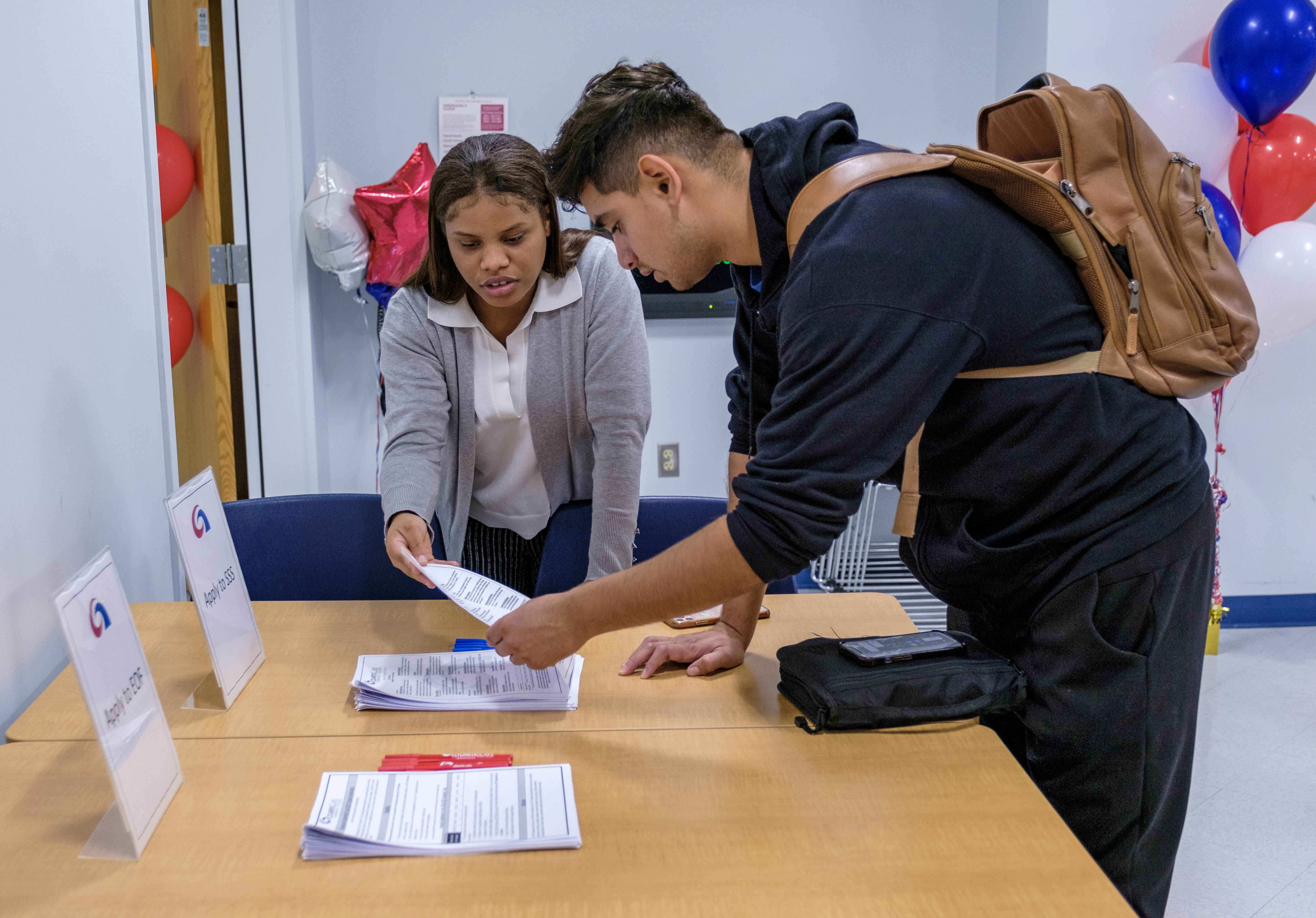 Student getting help from an employee with paperwork.