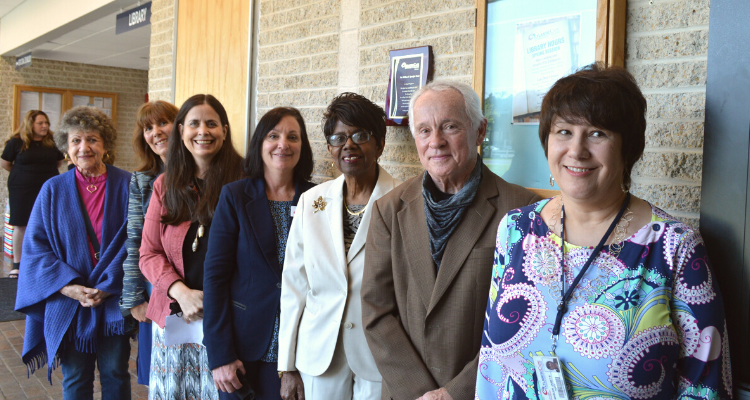 From left, Sandy Meischker, Josette Katz, Denise Coulter, Janet Hauge, Atlantic Cape President Barbara Gaba, Paul Rigby and Janet Marler stand in front of the plaque commemorating William Spangler at the library on the Mays Landing campus of Atlantic Cape Community College.