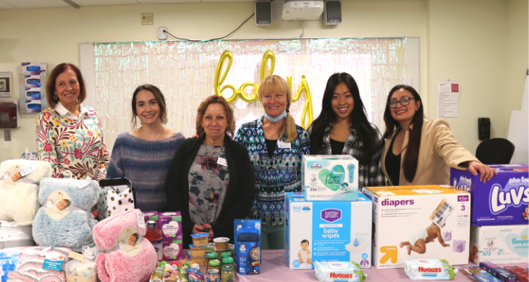 Students in the Nurses Club and Nursing faculty pose with donations at the SimMom Baby Shower event