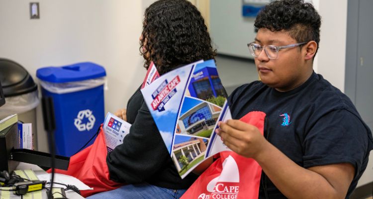 Student during College Awareness Day reads an Atlantic Cape information packet