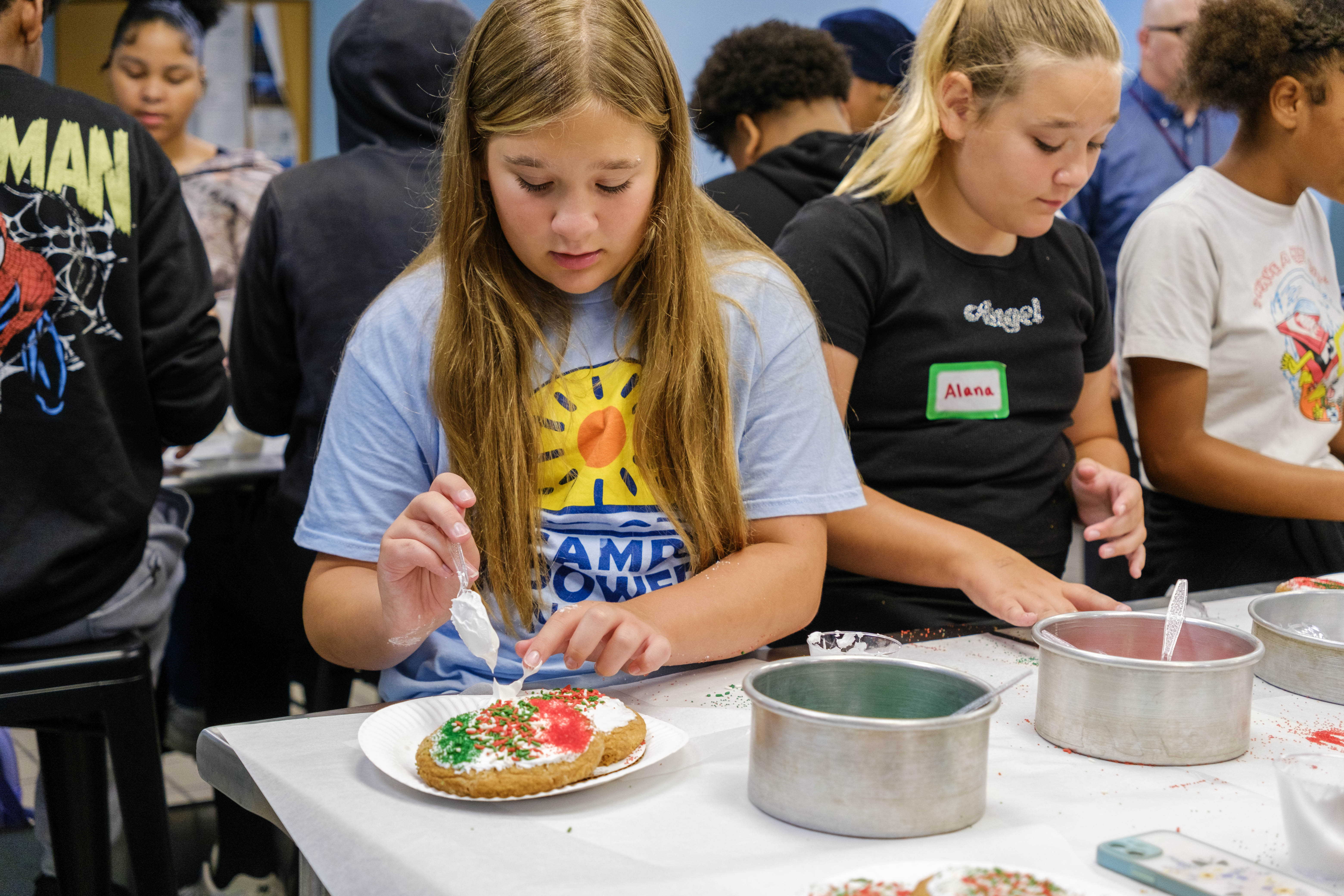 summer camp students decorating cookies