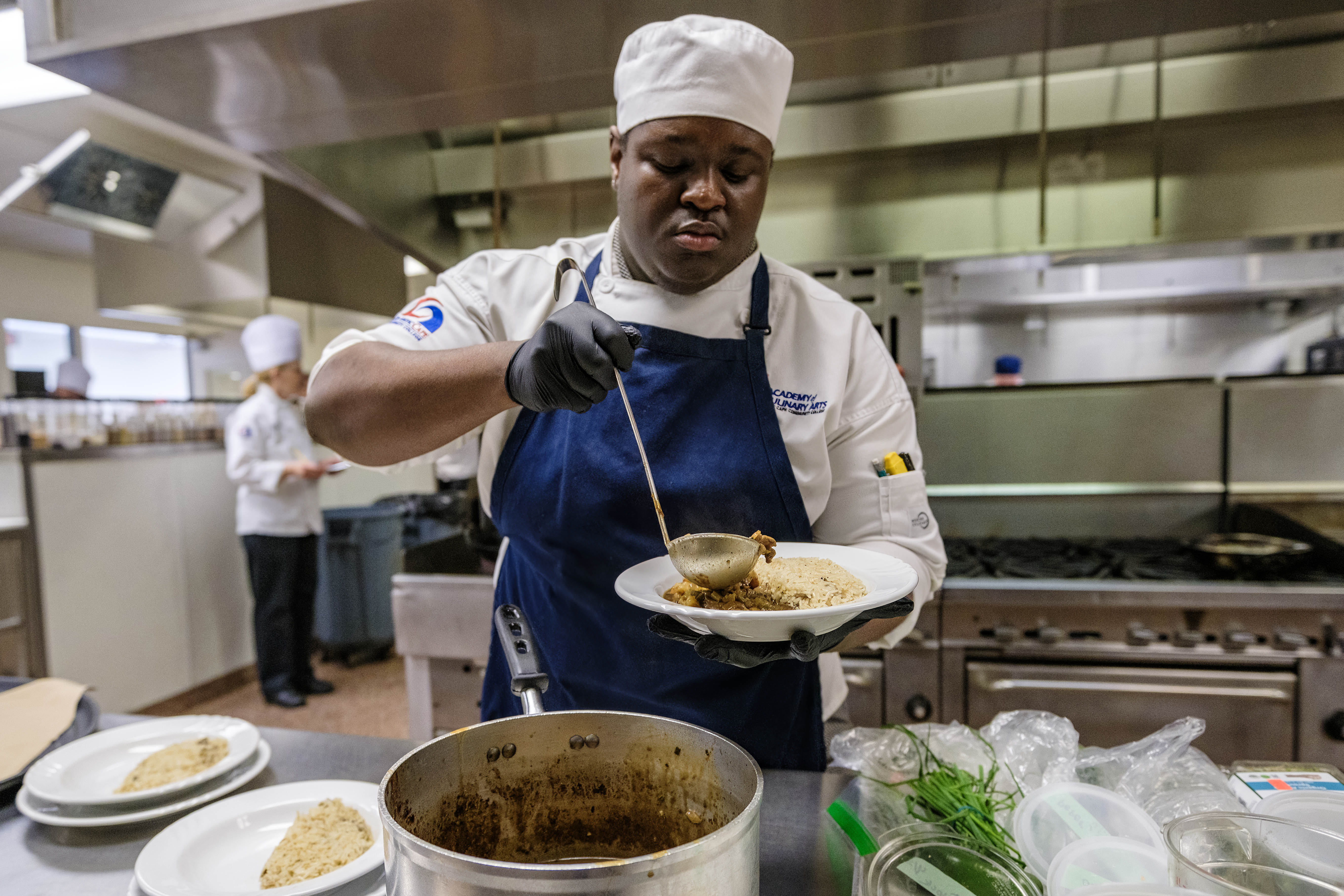 ACA student Saudley Delphin preparing spooning his dish