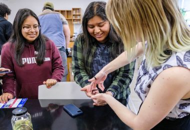 Students get a hands-on demonstration with a caterpillar