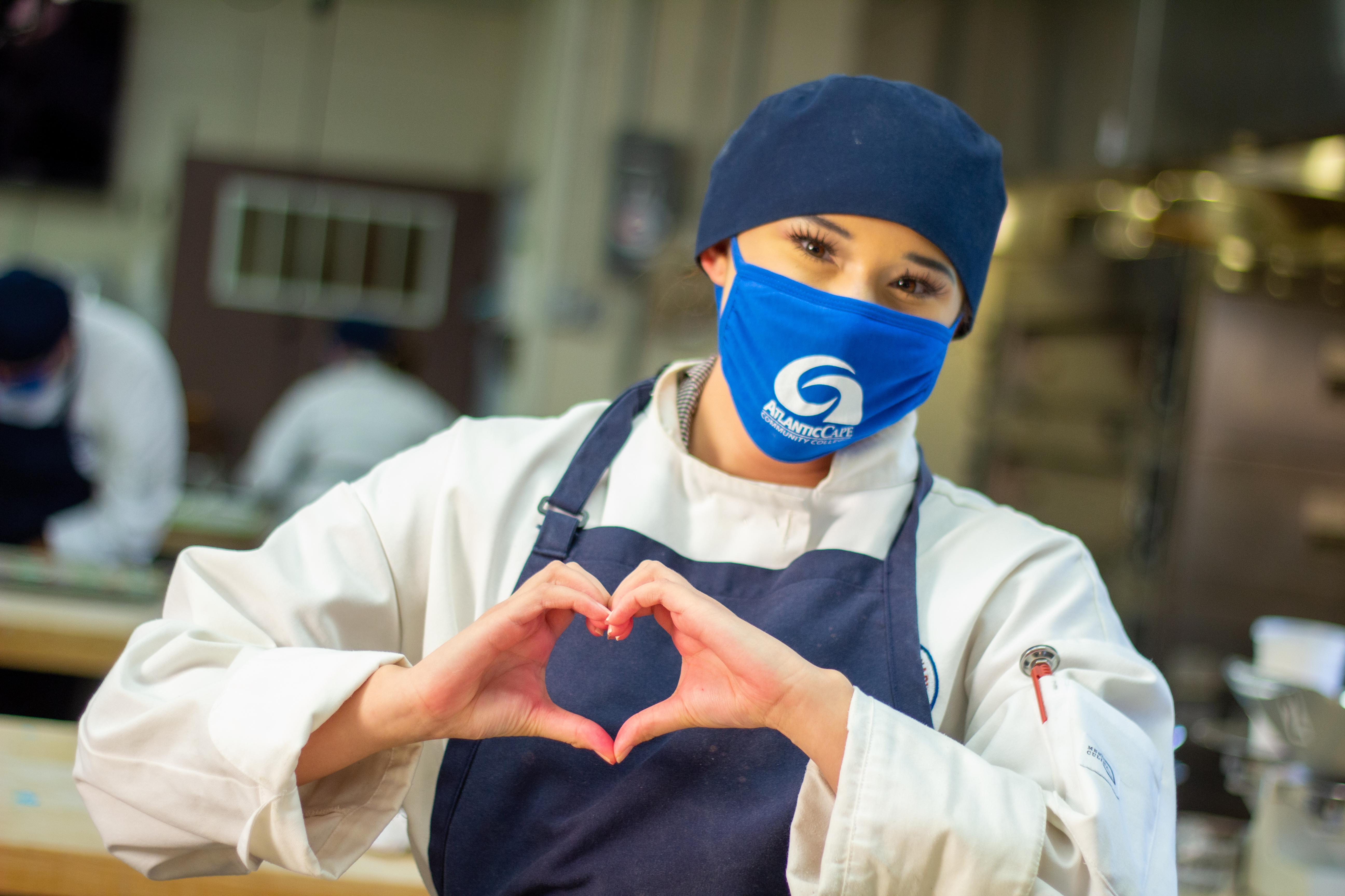 ACA Student wearing a mask making a heart symbol with her hands