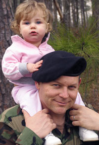 soldier carrying his toddler daughter on his back