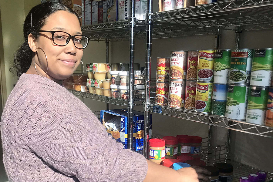 Person stocking the food pantry shelves.