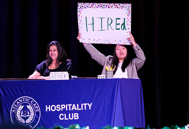 Fashion show judges holding up a sign