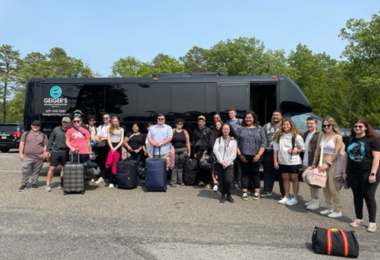 Culinary students await to board the bus that will take them to the airport