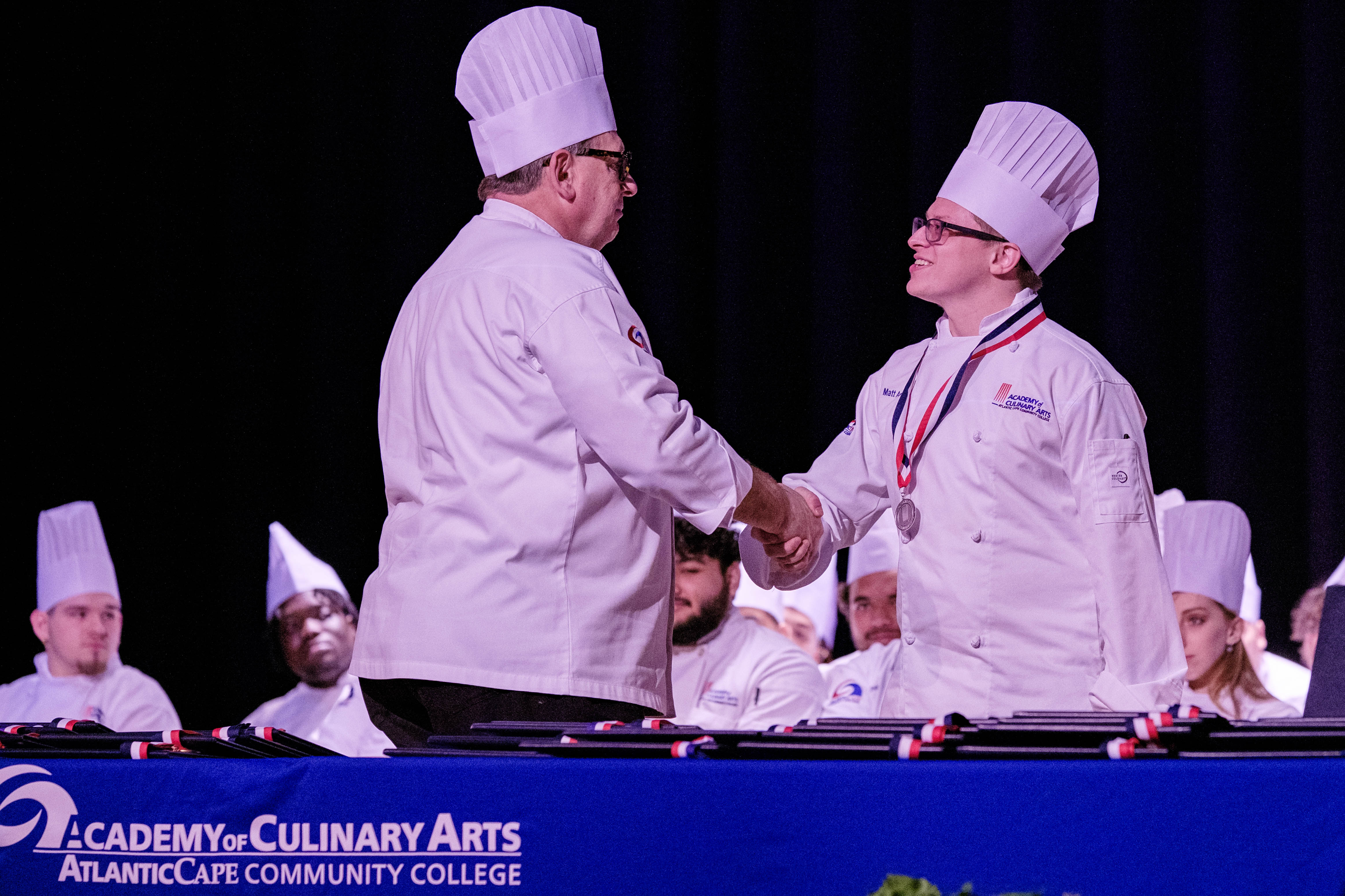 Chef Joseph Sheridan presents a medal to a graduate