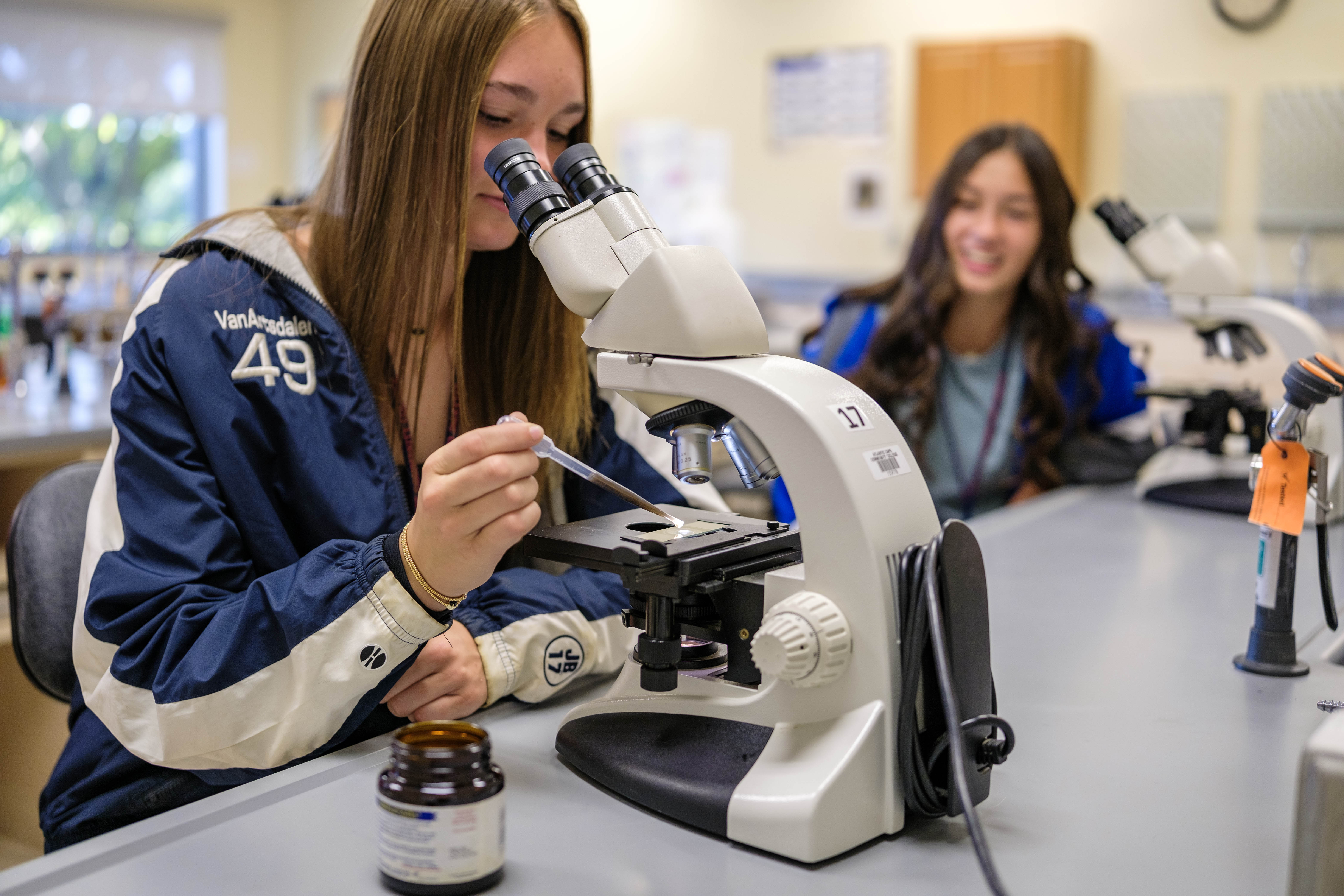 Student looks through a microscope