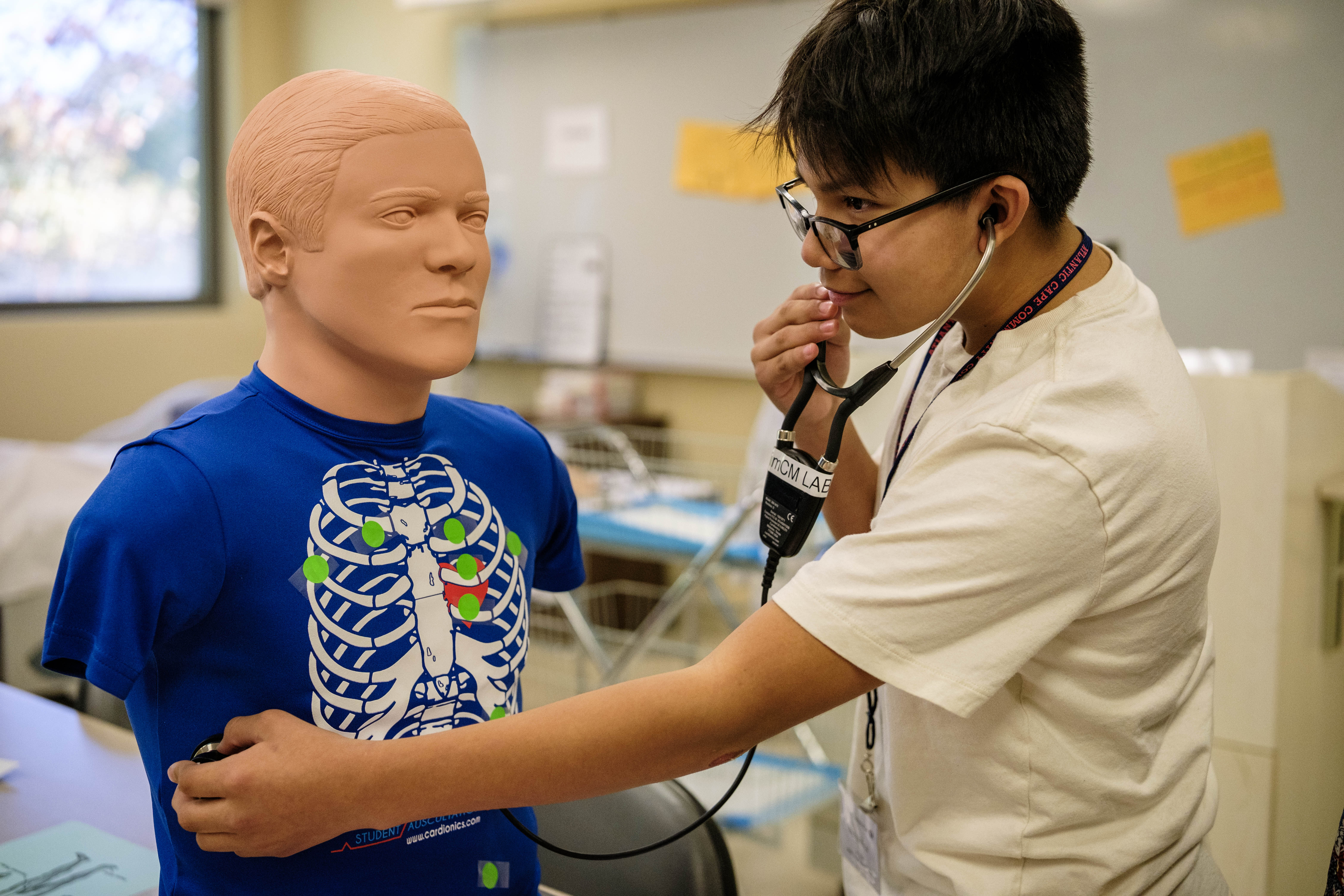 Student takes pulse on a mannequin