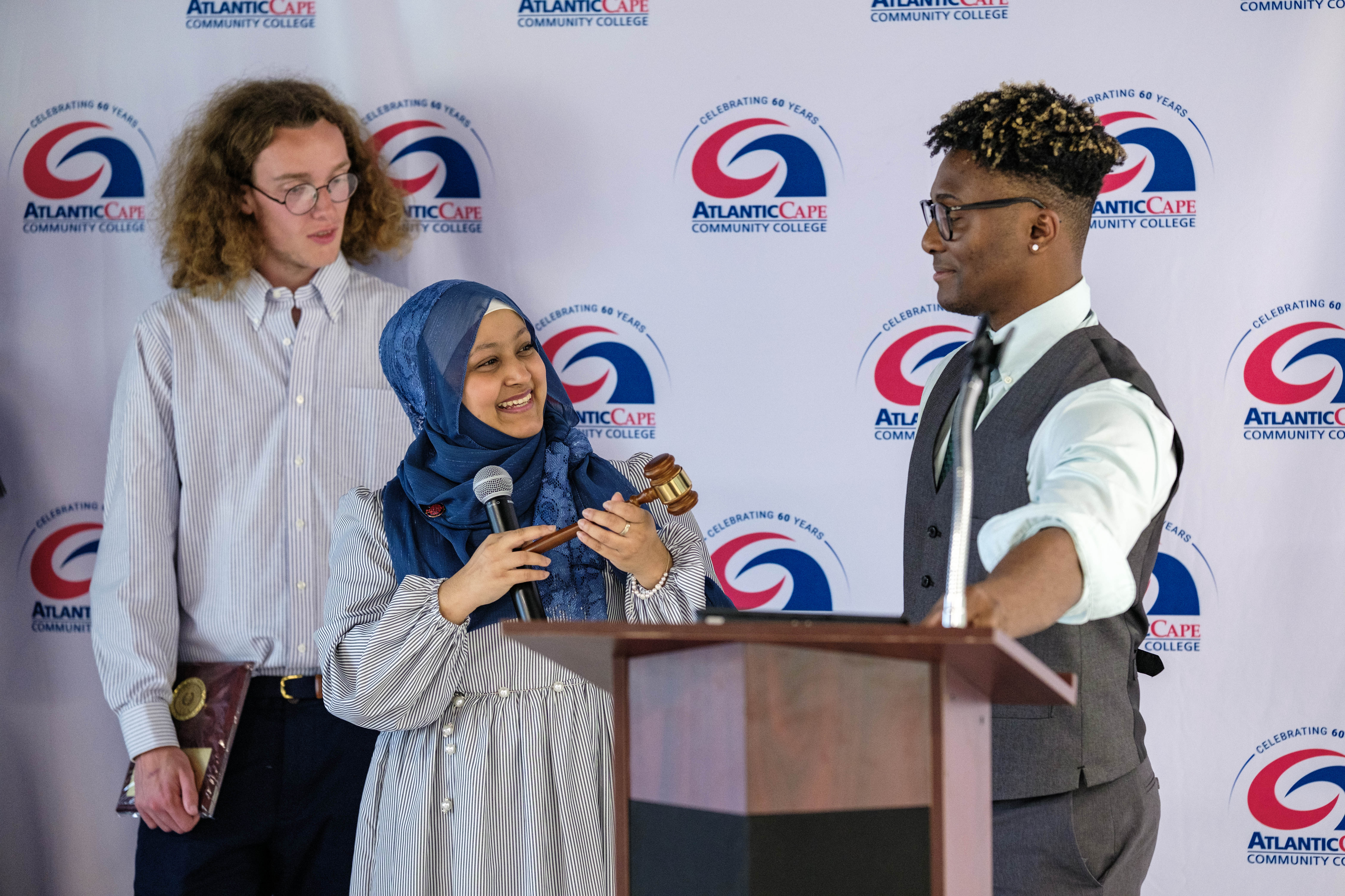 Outgoing SGA President Sultana Zakia presents the gavel to incoming president Juwan Torres