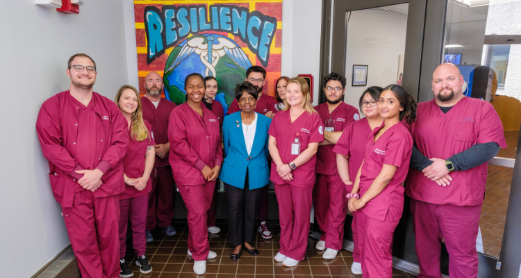 Atlantic Cape President Dr. Barbara Gaba stands with nursing students in front of the newly-unveiled Resilience painting